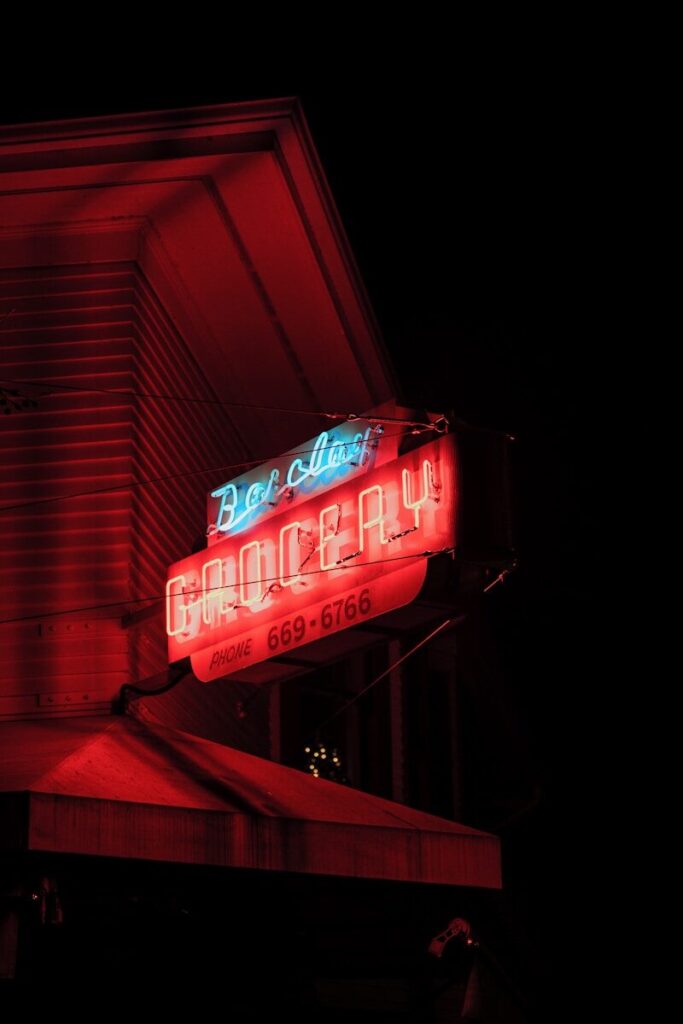 Red neon sign for a grocery store at night