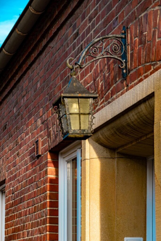 Antique lantern mounted on a brick wall.